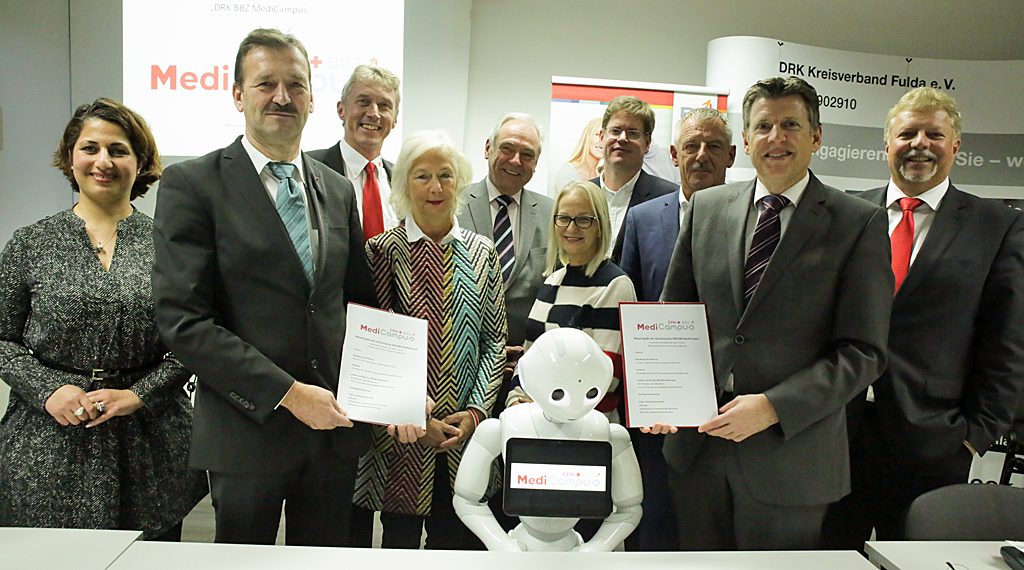 Die Verantwortlichen bei der Unterzeichnung des Kooperationsvertrages in der Geschäftsstelle des DRK Kreisverbandes Fulda e. V. mit Roboter „Pepper“.