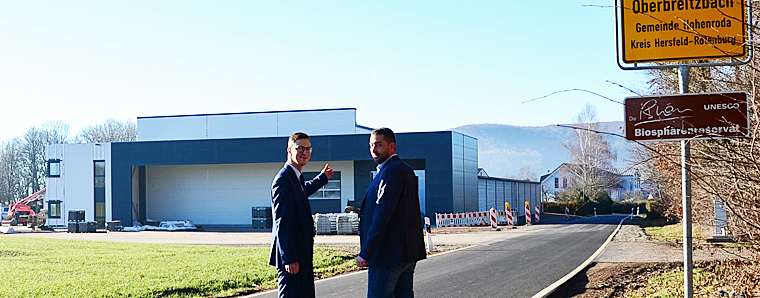Geschäftsführer Alexander August (rechts) zeigt Bürgermeister Andre Stenda deren neue Fertigungshalle mit Büroareal am Ortsrand von Oberbreitzbach.