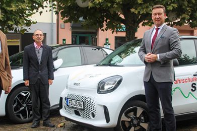 Bei der Präsentation der Elektroautos: Joachim Salfer (im Hintergrund) mit Christian Ackermann (links im Bild) und Bürgermeister Matthias Möller. Foto: b&r