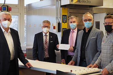 Kreisbeigeordneter Winfried Ottmann (Zweiter von links), Manfred Moritz (Mitte), Vorsitzender des Fördervereins der Beruflichen Schulen, Schulleiter Rainer Flach (Zweiter von rechts) und Hugo Klein (links) lassen sich von Bäckermeister Jürgen Hellmuth (rechts) vor dem neuen Ofen die Funktionsweise des Einschießgerätes erläutern.