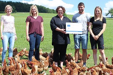 Bei ihrem Besuch am Hühnermobil der Familie Kreis in Bad Soden-Salmünster-Mernes überreichte Erste Kreisbeigeordnete Susanne Simmler (Mitte) zusammen mit Katrin Hess (Zweite von links) und Christina Gebhardt (links) vom Amt für Umwelt, Naturschutz und ländlichen Raum die Hinweistafel, die über die AFP-Förderung Auskunft gibt. Antonio Kreis und seine Frau Hanna nahmen die Tafel erfreut entgegen.