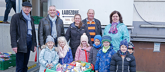 Yvonne Völler, Ina Plachtzik, Bürgermeister Carsten Froß und die Kinder der Kita
Zipfelmütze haben die Spenden an Stefan Schunck und Gerhard Krönung von der Fuldaer Tafel
übergeben. / Foto: Sebastian Kircher/Gemeinde Petersberg