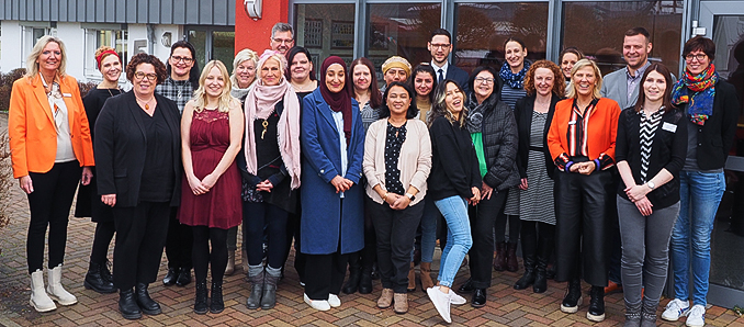 Erste Kreisbeigeordnete Susanne Simmler (Dritte von links), Gregor Hartsuiker (hinten, Mitte), Vorstand des Kommunalen Centers für Arbeit, und Gertraud Preuß (Achte von rechts), Geschäftsführerin der Gemeinnützigen Gesellschaft für Arbeit, Qualifizierung und Ausbildung, verabschiedeten gemeinsam mit Mitarbeitenden der AQA die Teilnehmerinnen des Seminars „Karrierestart mit Kind“.