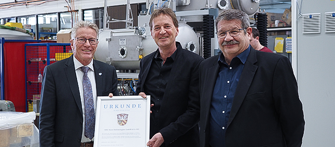 Kreisbeigeordneter Winfried Ottmann (links) überreichte gemeinsam mit Walter Dreßbach (rechts), Leiter des Referats für Wirtschaft, Arbeit und digitale Infrastruktur, dem Geschäftsführer der NTG Neue Technologien GmbH & Co. KG Thomas Franz die Auszeichnung „Made in Main-Kinzig“.