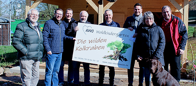 Unser Bild zeigt bei der Einweihung (von links): Erster Beigeordneter Ottmar Heck, Landrat Thorsten Stolz, Landtagsabgeordneter Christoph Degen, Rudolf Schulz und Simon Groß (AWO Obertshausen), Bürgermeister Jörn Schachtner, Irina Brettmann (Vorsitzende Sozial- Kultur- und Sportausschuss) und Uwe Reifenberger (Verein Neuberger Dorffeste) mit dem neuen Kita-Schild.