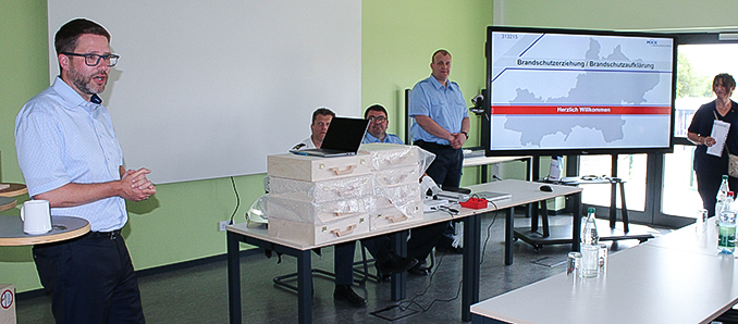 Brandschutzerziehung als Sachunterrichtsthema: Landrat Thorsten Stolz (links), Susanne Fries vom Staatlichen Schulamt sowie ein Team aus Haupt- und Ehrenamtlichen um Brandschutzkoordinator Oliver Groß (stehend, Mitte) freuen sich über weitere 13 Grundschulen, die dabei mitmachen.