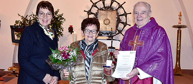 Pfarrer Peter Hannappel (rechts) zeichnete gemeinsam mit Beate Reinhardt (links) Frau Christa Reinhardt (Mitte) in der Kirche in Wölf mit der Elisabeth-Medaille des Bistums Fulda aus.. Foto: wim