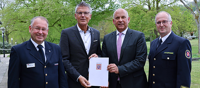 Norbert Fischer (Präsident des Landesfeuerwehrverbands), Erster Kreisbeigeordneter Dirk Noll, Innenminister Roman Poseck und Kreisbrandinspektor Marco Kauffunger (von links) freuen sich über den Zuwendungsbescheid. Foto: Landkreis Hersfeld-Rotenburg